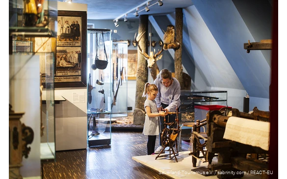 Eine Mutter erkundet mit ihren Kindern das Südsauerlandmuseum in Attendorn.