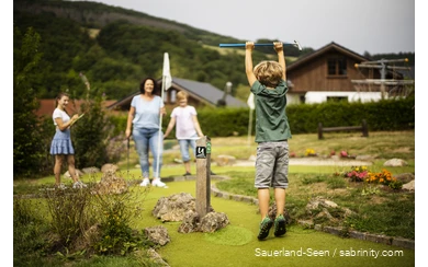 Familie spielt Minigolf