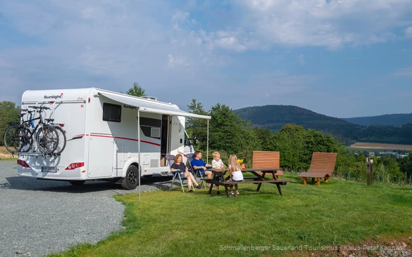 Eine Familie genießt ihren Campingurlaub im Grünen.