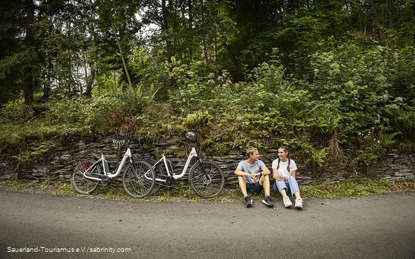 Radfahrerpärchen macht eine Pause am Wegesrand.