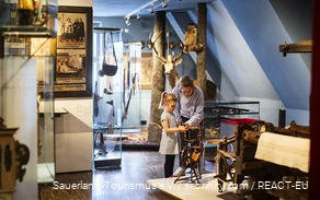 Eine Mutter erkundet mit ihren Kindern das Südsauerlandmuseum in Attendorn.