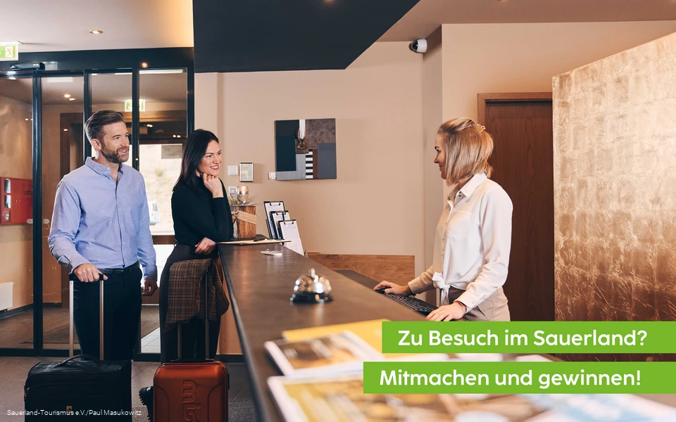 Hotelgäste checken an der Rezeption ein