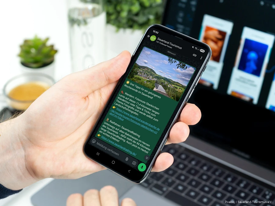 PI_Sauerland-Tourismus startet eigenen WhatsApp-Kanal Ein Smartphone wird in der Hand gehalten. Auf dem Bildschirm sieht man einen Post im neuen WhatsApp-Kanal des Sauerland-Tourismus.