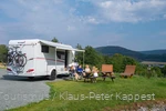 Eine Familie genießt ihren Campingurlaub im Grünen.